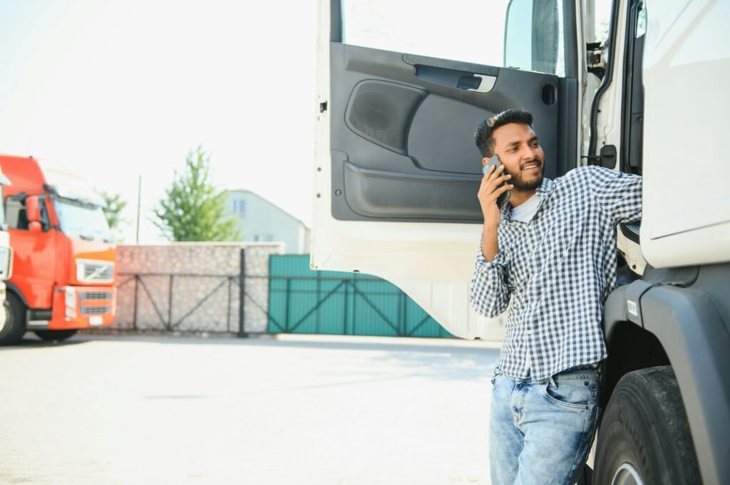 Indian truck driver tending a client on the phone